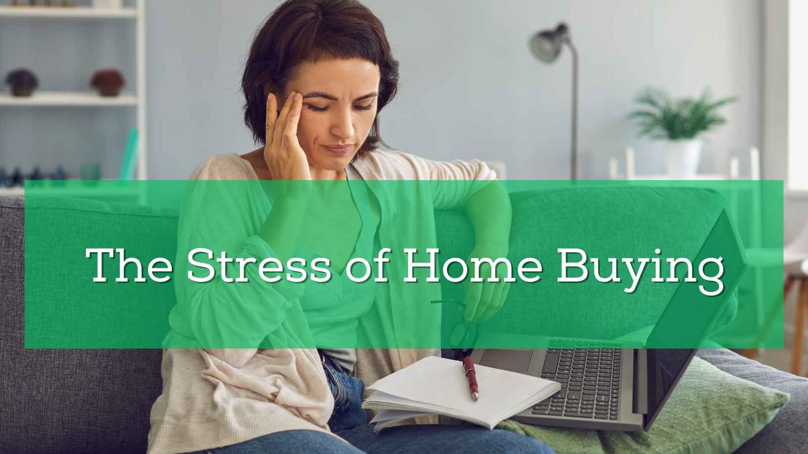 A woman holds her head because of the stress of home buying