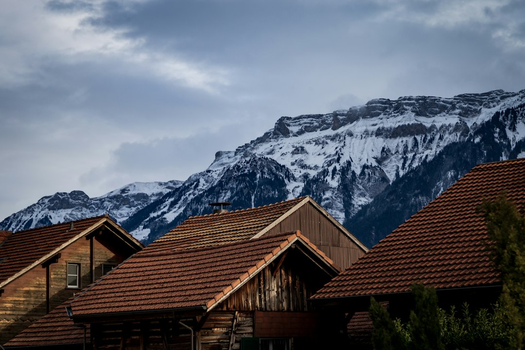 The exterior of a sleek, modern Denver home with the Rocky Mountains visible in the background, representing the 1% listing fee real estate trend.